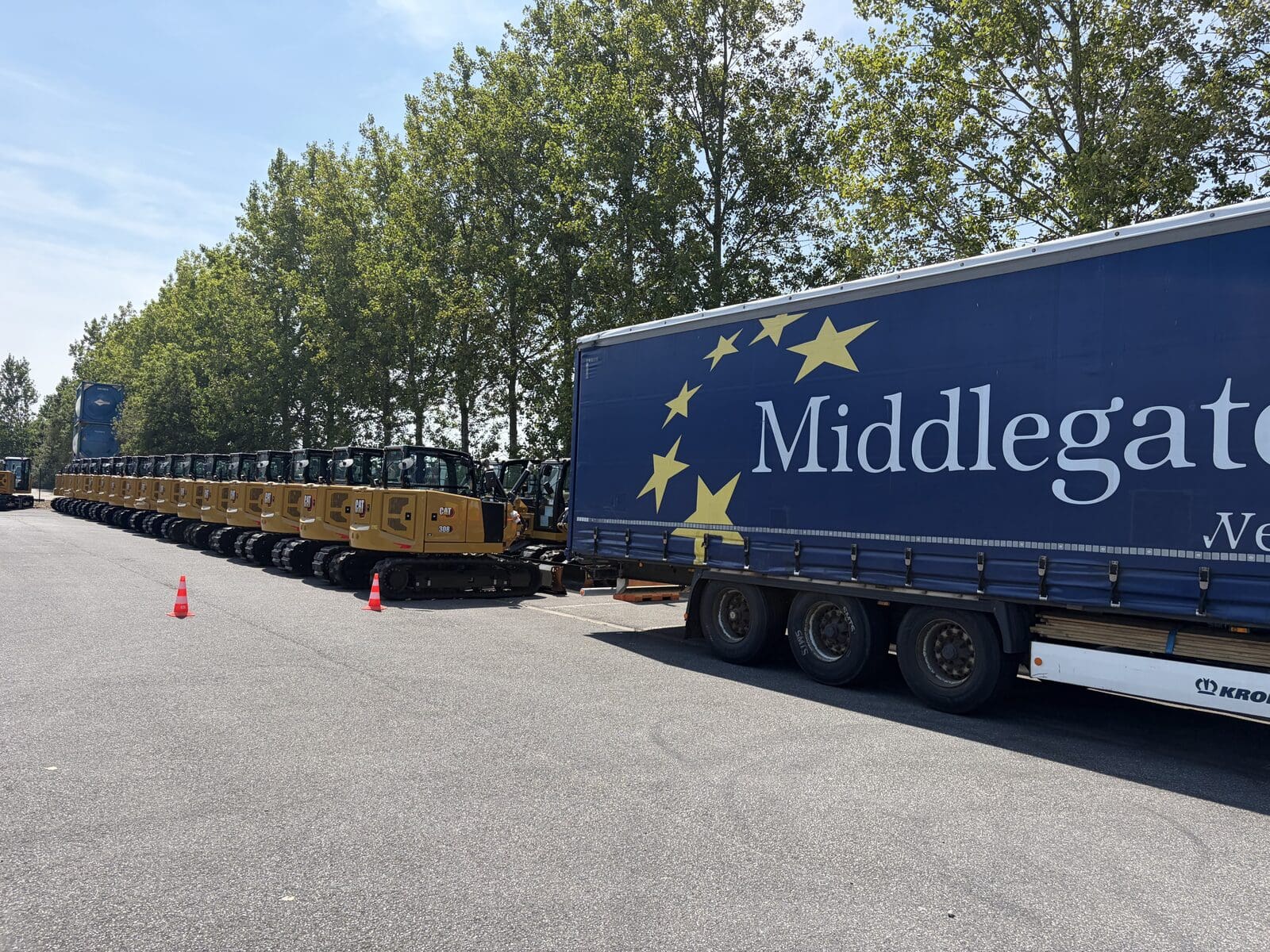Row of new CAT mini excavators next to a Middlegate Europe trailer at the Zeebrugge warehouse